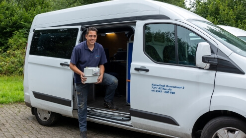 Blije monteur met gasmeter in handen - officieel erkend voor gasmeter, elektriciteitsmeters, EVHI's en het installeren van grootverbruikers - 495x278px